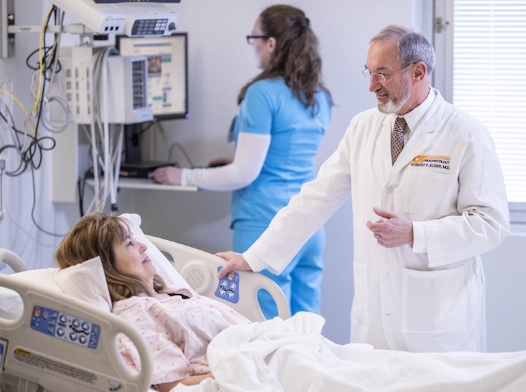 Doctor speaking to woman in hospital bed