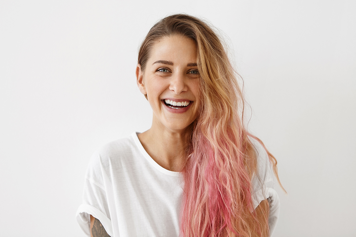 young smiling woman with pink hair