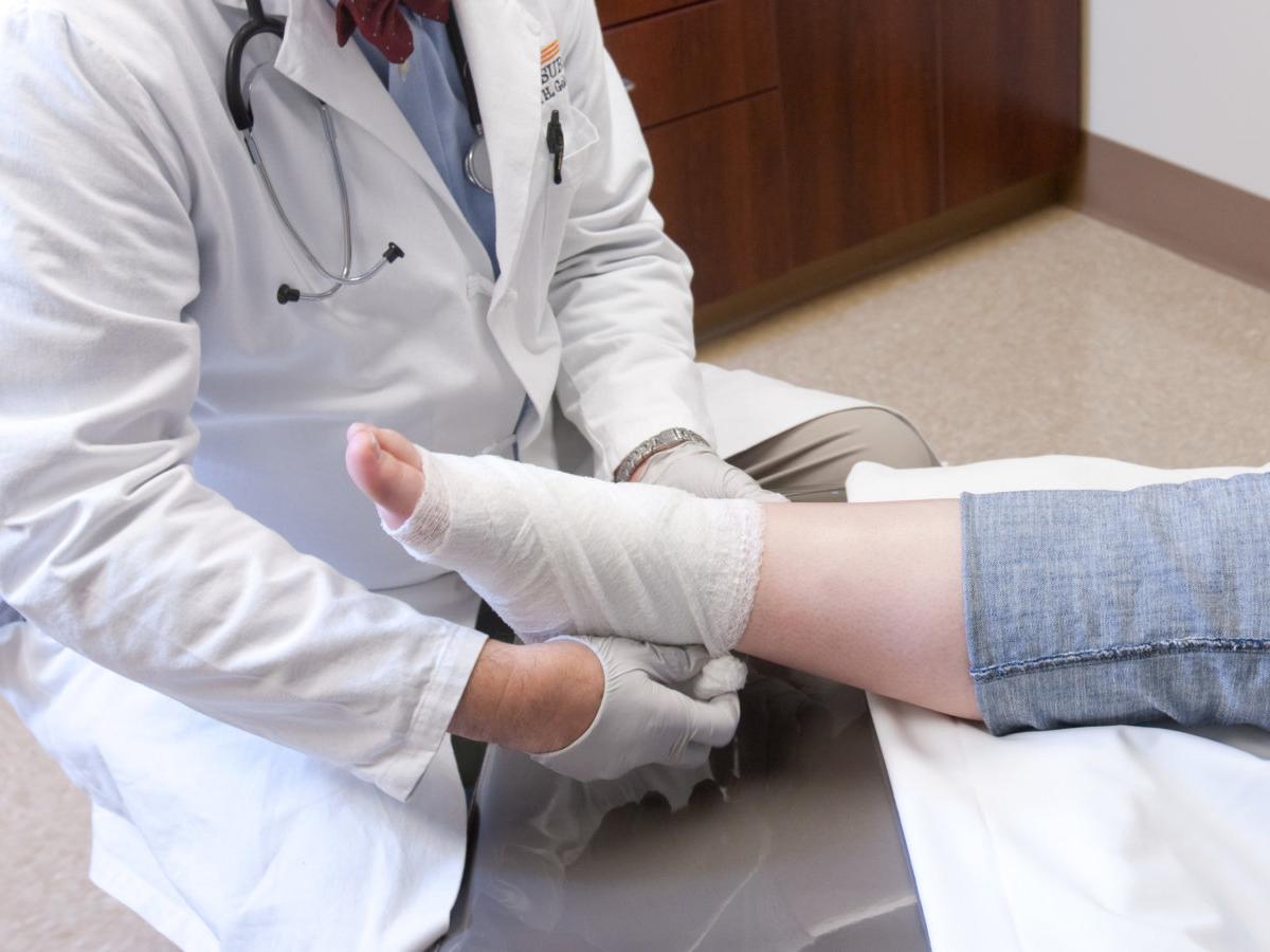 A doctor wraps a patient's ankle