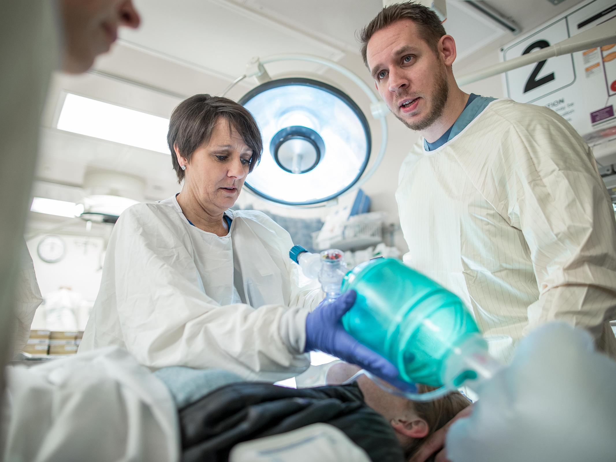 A team of emergency room providers works on a patient