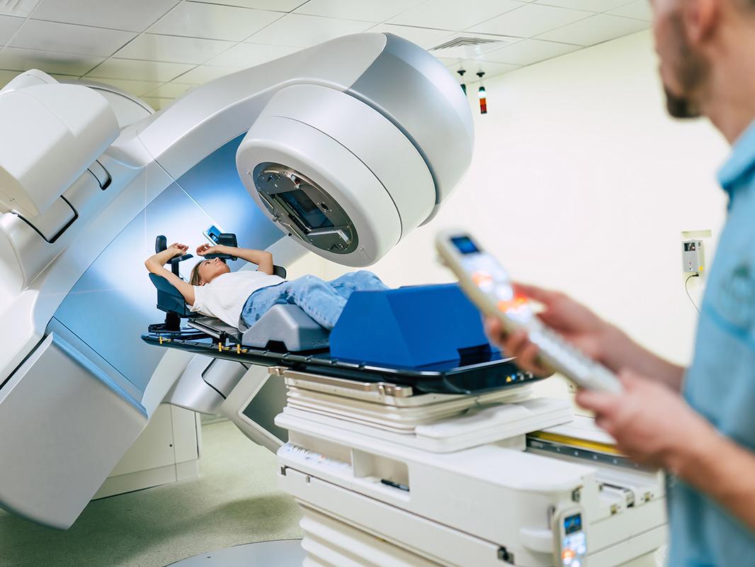 A radiation technologist operates a radiation machine on a patient