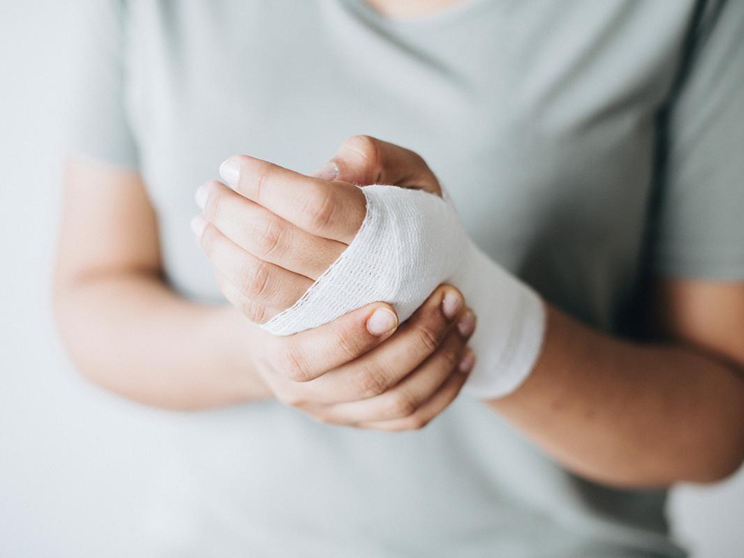 A woman holds her bandaged hand