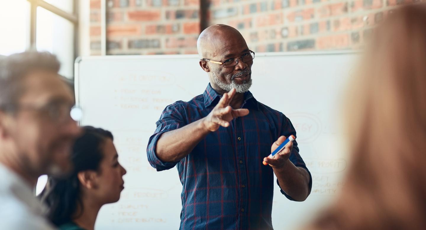 A mature black man leads a meeting