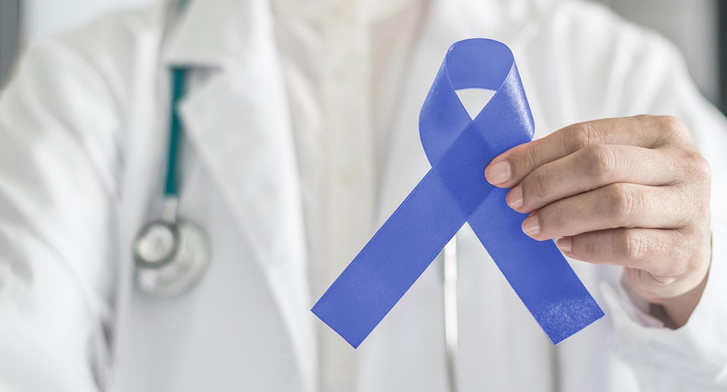 A female doctor holds a purple ribbon for esophageal cancer
