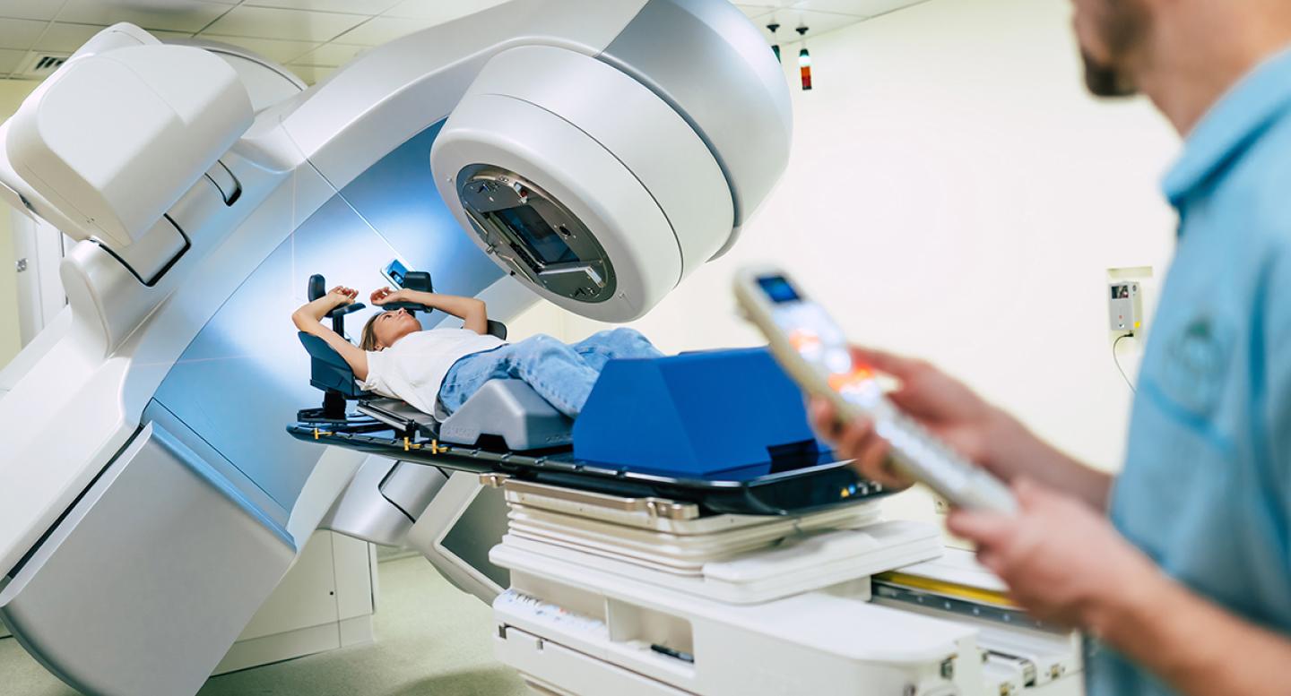 A radiation technologist operates a radiation machine on a patient