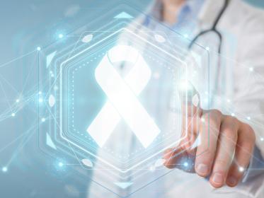 A doctor points at a graphic of a cancer ribbon
