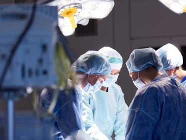 A group of surgeons operating in a hospital operating room