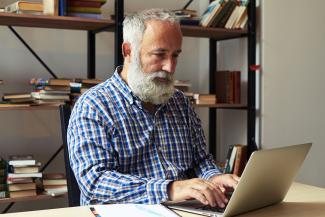 man with beard on laptop