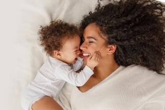 Young mother and baby touching noses and smiling