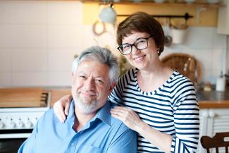 A man and woman smiling together in a kitchen