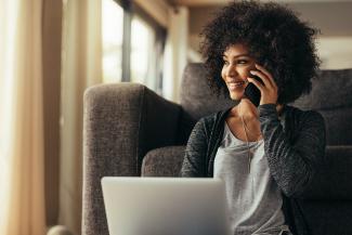 A woman sitting with her laptop and on the phone