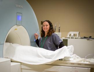 nurse standing by patient in CT scanner
