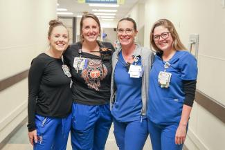 Four Emergency Department nurses standing together in a hospital hallway