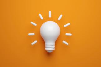 White light bulb on orange background