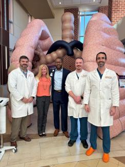 Dr. Benjamin Bevill, Emily McClure, Dr. Keith Gray, Dr. Sean Jordan, Dr. Christian Probst stand in front of the Mega Lungs at a medical center event