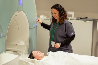 An MRI tech pauses to talk with a patient before she goes through the MRI machine