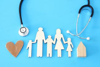 A paper doll family with a stethoscope - primary care concept