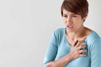 A woman clutches her chest in pain