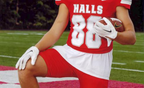 A young adult poses in his football uniform