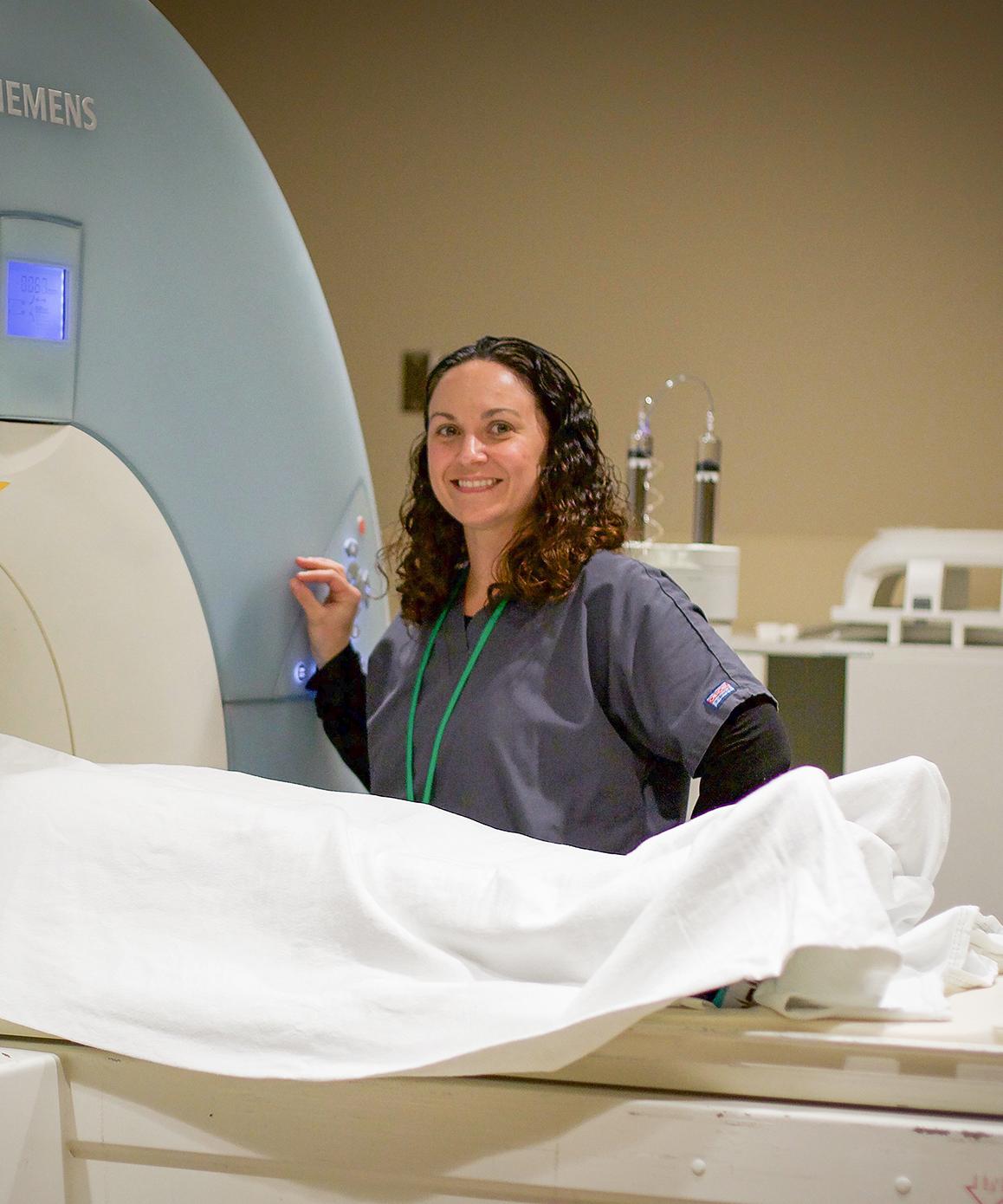 nurse standing by patient in CT scanner