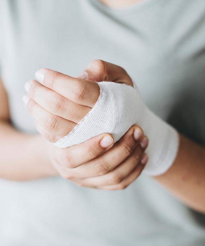 A woman holds her bandaged hand